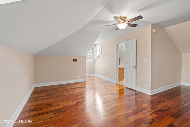 bonus room featuring dark hardwood / wood-style flooring, vaulted ceiling, and ceiling fan