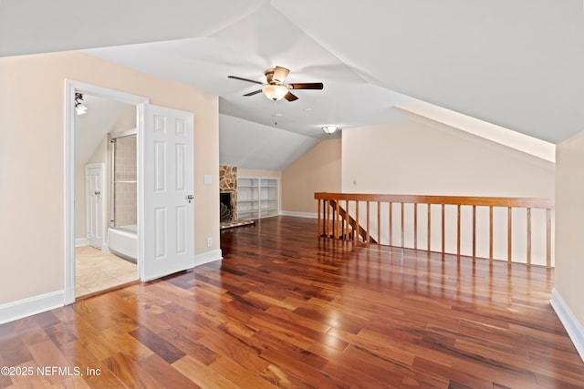 additional living space with vaulted ceiling, hardwood / wood-style floors, and ceiling fan