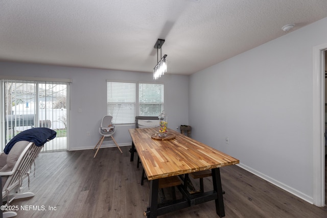 dining room with baseboards, dark wood finished floors, and a textured ceiling