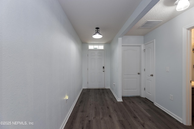 doorway to outside featuring dark wood-style flooring, visible vents, and baseboards