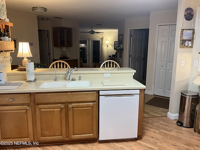 kitchen with dishwasher, sink, and light wood-type flooring