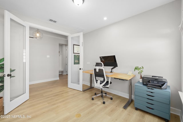 home office featuring baseboards, visible vents, wood finished floors, and french doors