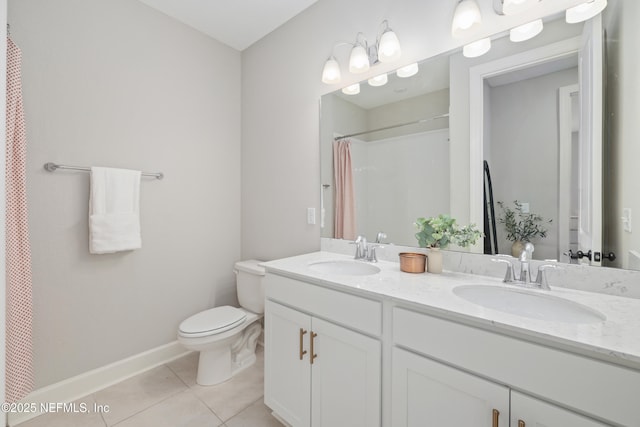 bathroom with double vanity, a sink, toilet, and tile patterned floors