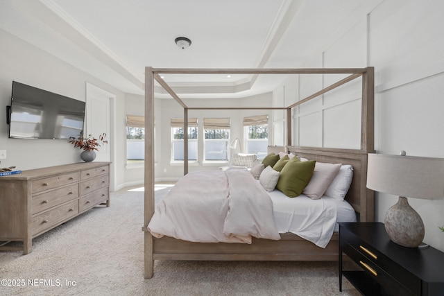 bedroom featuring crown molding, a tray ceiling, and light colored carpet