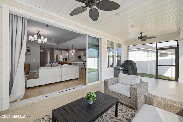 sunroom / solarium featuring a chandelier, a tray ceiling, a sink, and visible vents