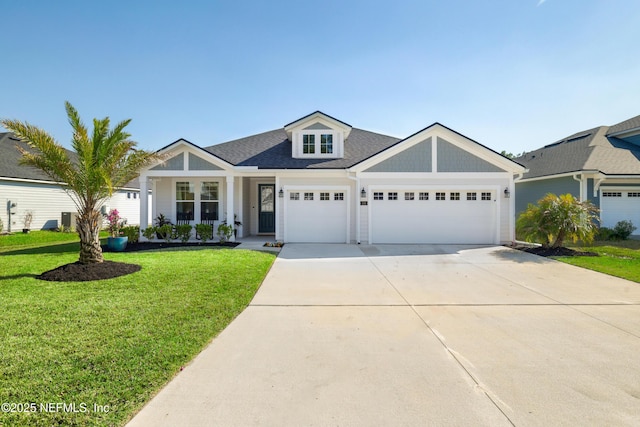 view of front of home featuring a shingled roof, a front yard, driveway, and an attached garage