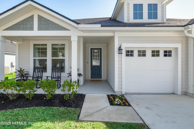 entrance to property featuring a porch, concrete driveway, a shingled roof, and a garage