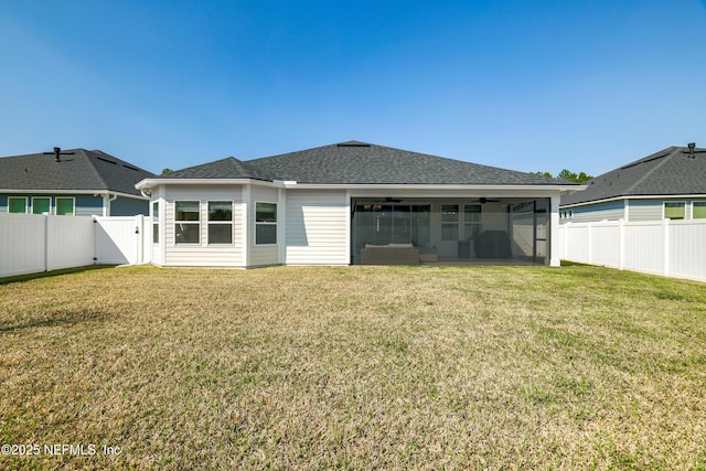 back of house featuring a fenced backyard, a shingled roof, a ceiling fan, a lawn, and a gate