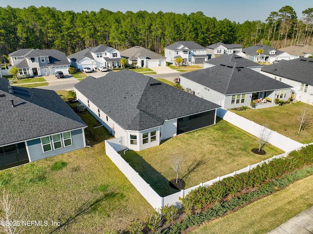 birds eye view of property featuring a wooded view and a residential view