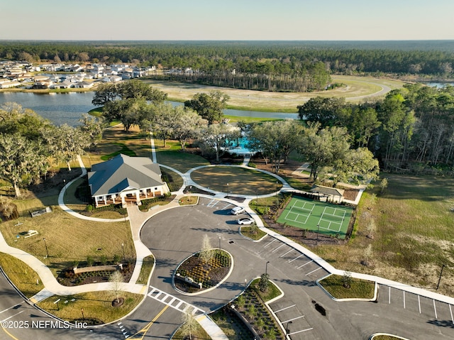 birds eye view of property with a water view and a wooded view