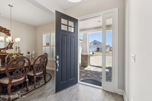 entrance foyer featuring an inviting chandelier, light hardwood / wood-style flooring, and a healthy amount of sunlight