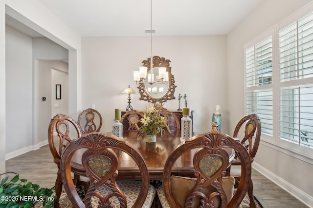 dining room with hardwood / wood-style flooring and a chandelier