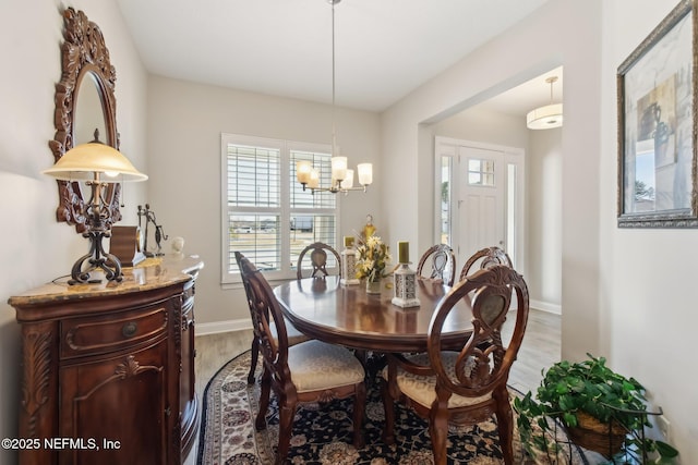 dining space featuring hardwood / wood-style flooring and a notable chandelier