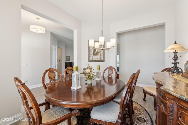 dining room with a notable chandelier and wood-type flooring