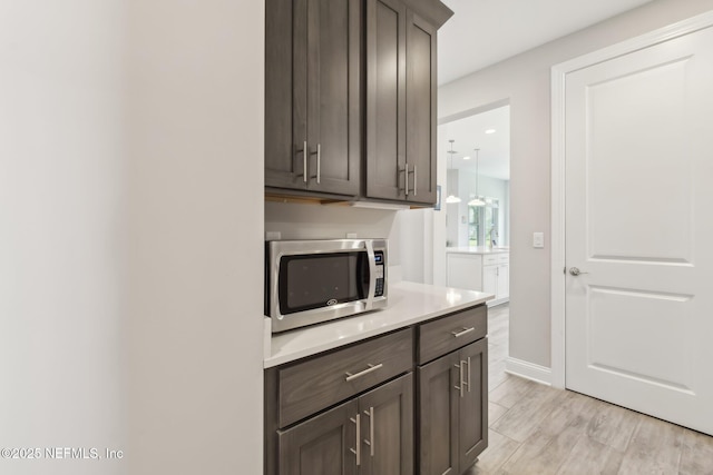 kitchen featuring dark brown cabinets and light wood-type flooring