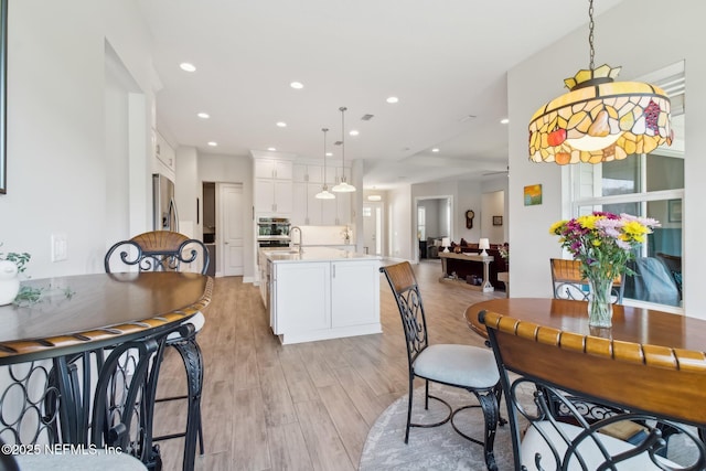 dining area with sink and light hardwood / wood-style flooring