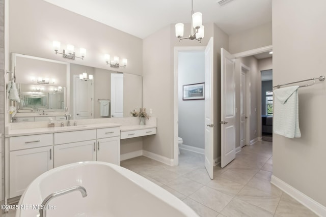 bathroom with tile patterned flooring, vanity, a notable chandelier, a tub, and toilet