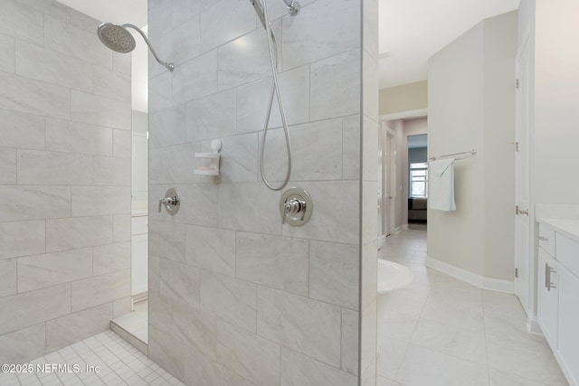 bathroom featuring tile patterned floors, vanity, and a tile shower