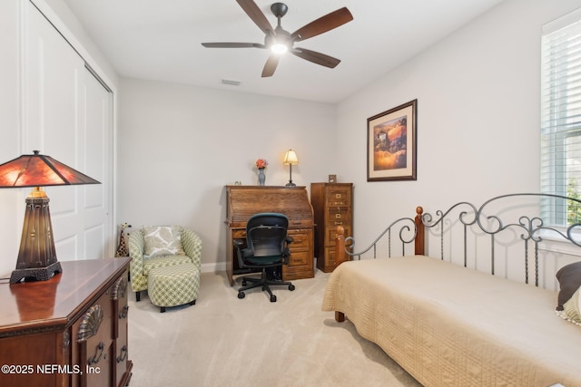 bedroom featuring ceiling fan, multiple windows, a closet, and light carpet