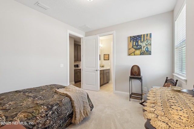 carpeted bedroom featuring ensuite bath