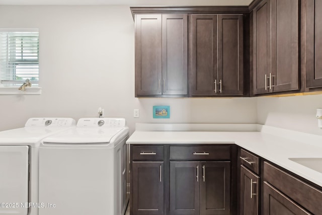 laundry room featuring separate washer and dryer and cabinets