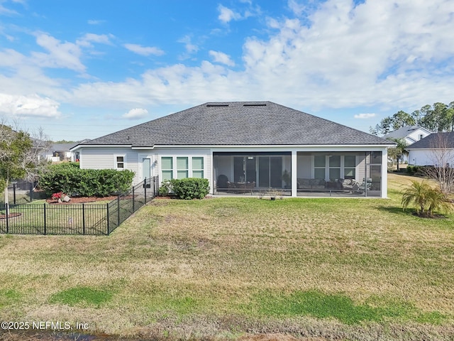 rear view of house with a lawn and a sunroom