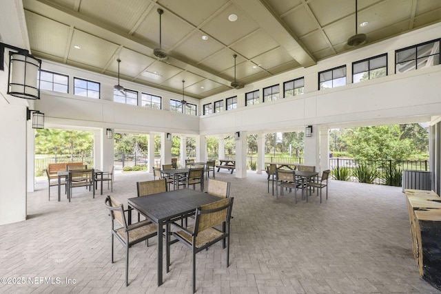 sunroom / solarium featuring beam ceiling and plenty of natural light