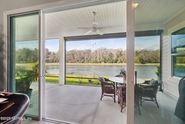 sunroom / solarium featuring a water view and ceiling fan