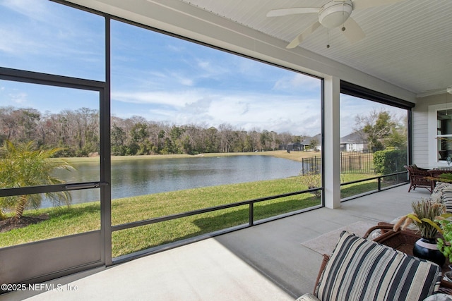 sunroom / solarium featuring plenty of natural light, ceiling fan, and a water view