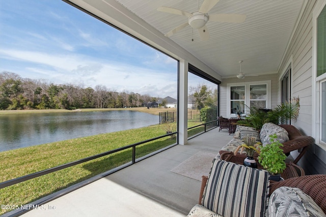 sunroom featuring a water view and ceiling fan