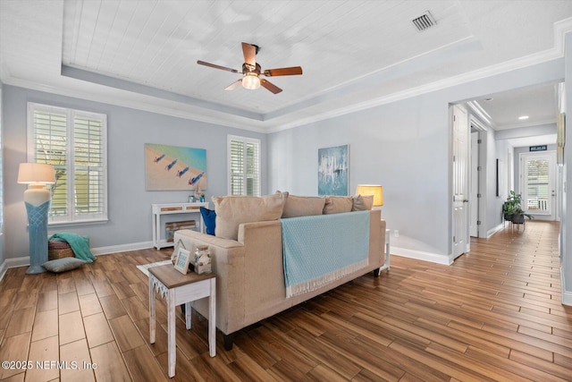 living room with hardwood / wood-style flooring, crown molding, and a tray ceiling