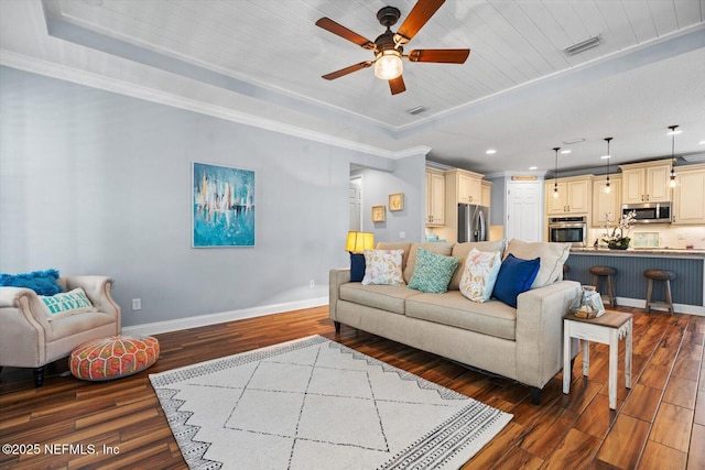 living room with dark wood-type flooring, wooden ceiling, ornamental molding, a tray ceiling, and ceiling fan