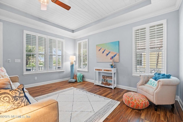 living room featuring hardwood / wood-style flooring, plenty of natural light, a tray ceiling, and crown molding