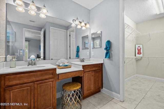 bathroom with vanity, tile patterned flooring, and a textured ceiling