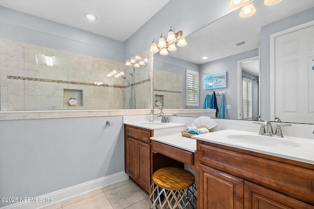 bathroom featuring tile patterned flooring, vanity, and tiled shower