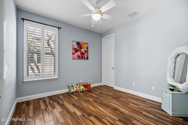 interior space featuring a textured ceiling, dark hardwood / wood-style floors, and ceiling fan