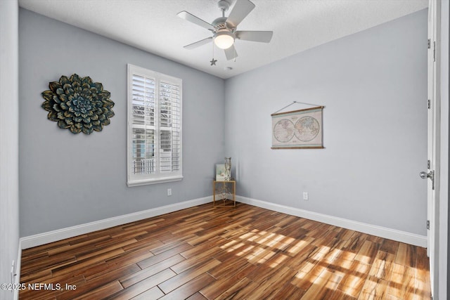 empty room with a textured ceiling, dark wood-type flooring, and ceiling fan