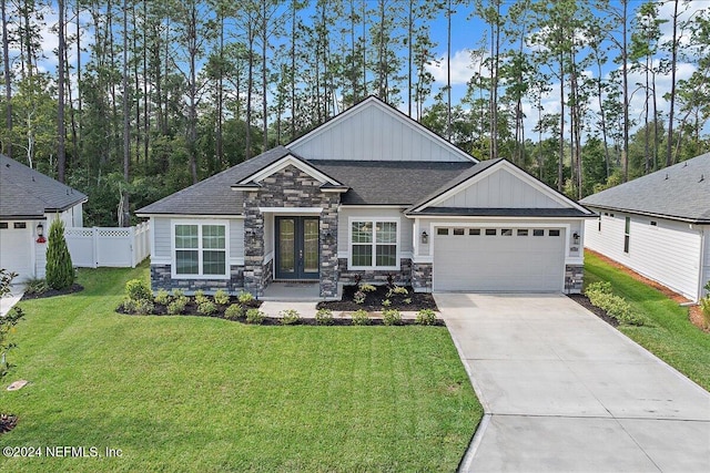 view of front of property featuring a garage, a front lawn, and french doors