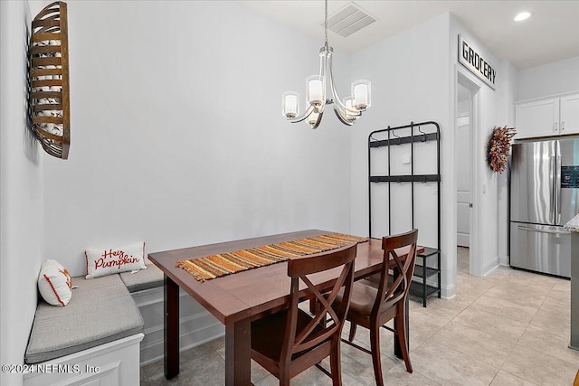 tiled dining room featuring an inviting chandelier and breakfast area