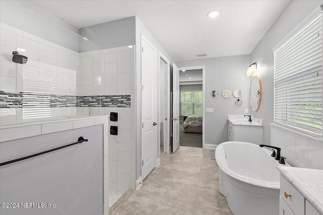 bathroom with tile patterned flooring, vanity, independent shower and bath, and a textured ceiling