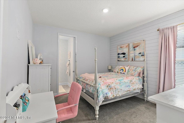 bedroom featuring carpet floors, a textured ceiling, and wood walls