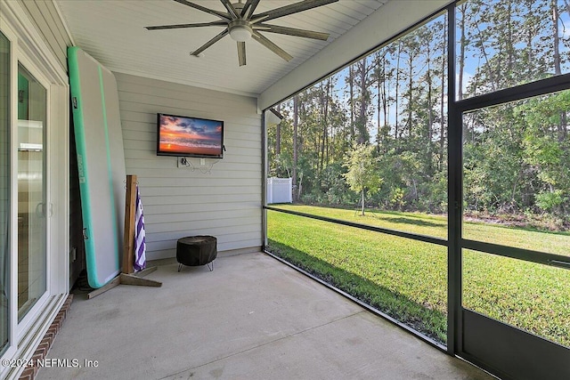 unfurnished sunroom featuring ceiling fan