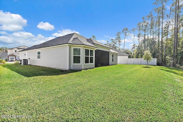 back of property with cooling unit and a yard