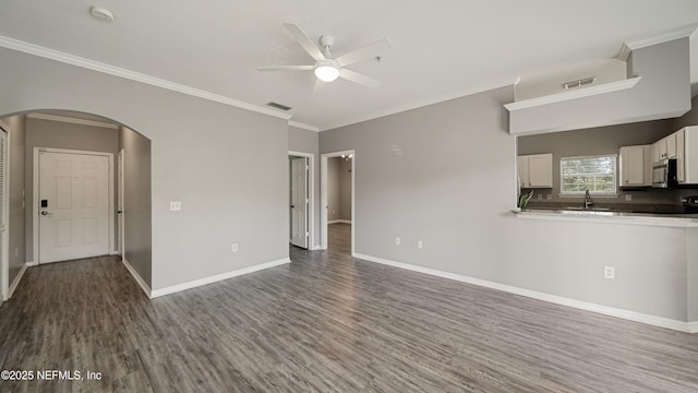 unfurnished living room with crown molding, sink, hardwood / wood-style floors, and ceiling fan