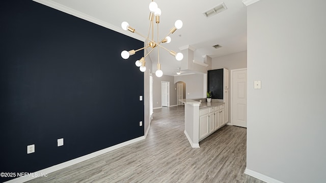 interior space featuring an inviting chandelier and light hardwood / wood-style flooring