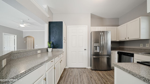 kitchen featuring white cabinetry, light hardwood / wood-style flooring, appliances with stainless steel finishes, ceiling fan, and dark stone counters