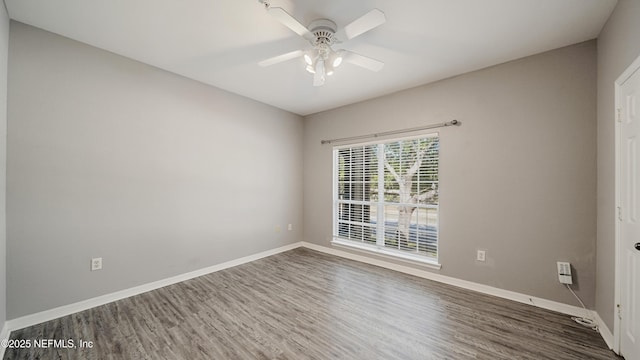 spare room with dark wood-type flooring and ceiling fan