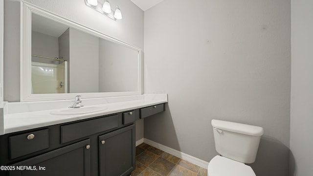 bathroom featuring vanity, toilet, and walk in shower