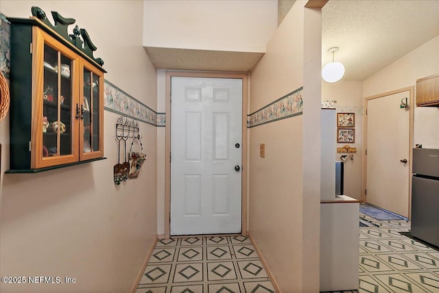 doorway to outside featuring a textured ceiling