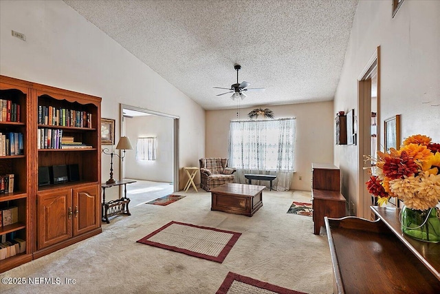 living room with lofted ceiling, a wealth of natural light, light colored carpet, and a textured ceiling